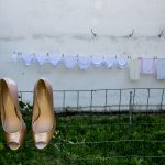 παπούτσια της νύφη κρεμασμένα στα κάγκελα, από πίσω απλωμένα εσώρουχα