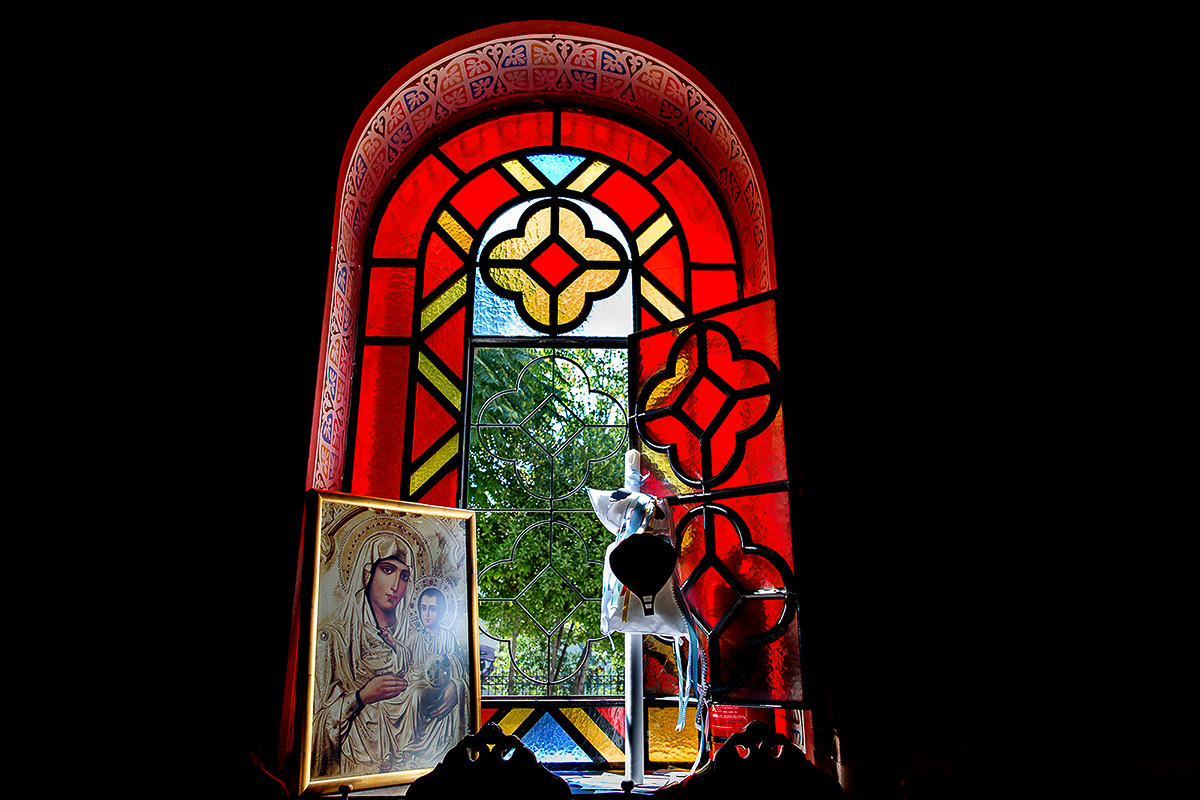 το παράθυρο της εκκλησίας , κόκκινο βιτρό. εικόνα της Παναγίας.