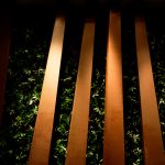 ξύλινα δοκάρια ανάμεσα σε τοίχο από πλαστικά φυτά