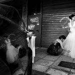 ασπρόμαυρη φωτογραφία από το γάμο, μια φίλη της νύφης της φτιάχνει το νυφικό