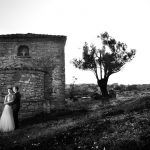 ασπρόμαυρη φωτογραφία γάμου, το ζευγάρι πίσω από τον πέτρινο ναό