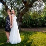 έγχρωμη φωτογραφία γάμου, η νύφη με την κουμπάρα κάτω από το δέντρο.