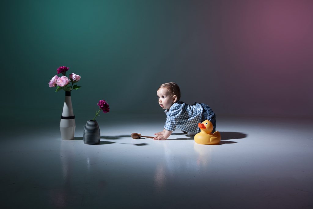 ο Δημήτρης μπουσουλώντας προσπαθεί να φτάσει ένα μεταλλικό βάζο με πλαστικά λουλούδια