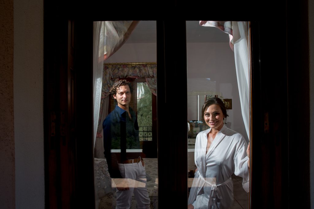 Η νύφη και ο γαμπρός μέσα από ένα παράθυρο.