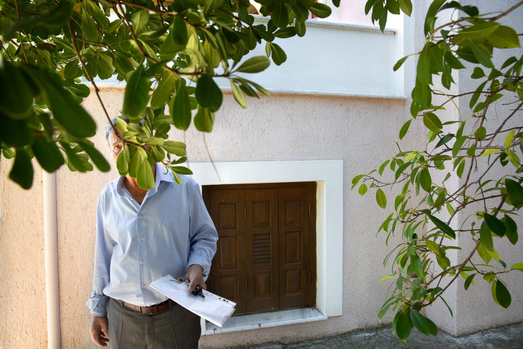 ο πατέρας της νύφης κρυφοκοιτάει μέσα από τις φυλλωσιές ενός δέντρου.