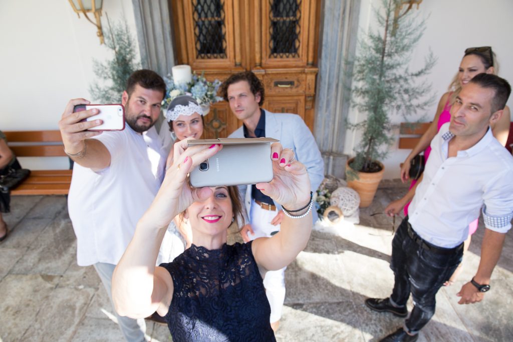 μια φίλη προσπαθεί να βγάλει selfie την ίδια, το ζεύγος και τον κουμπάρο.
