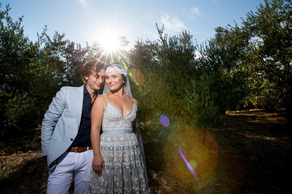 το ζευγάρι αγκαλιασμένο κα ο ήλιος από πίσω τους.