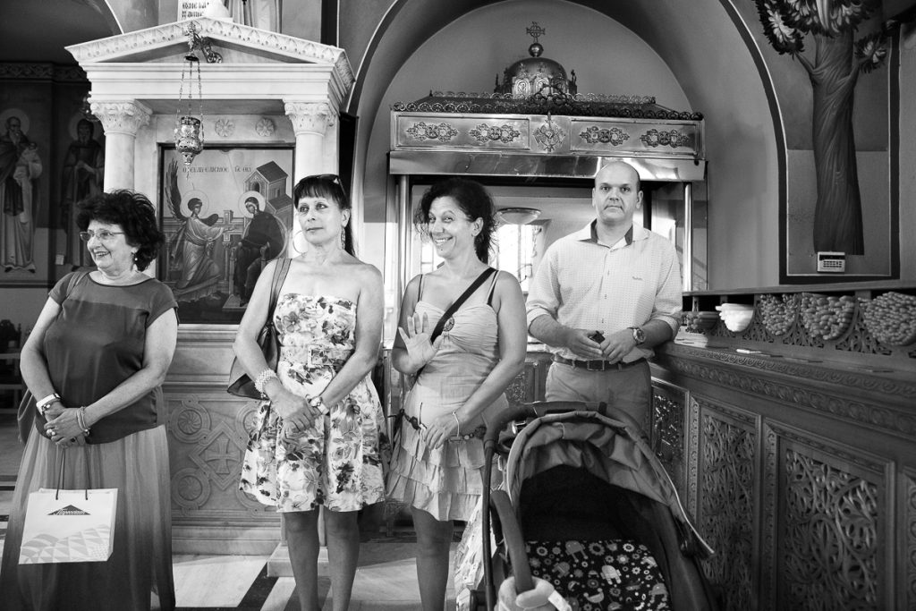 κοπέλα χαιρετάει ενώ τρεις άλλοι παρακολουθούν τη βάπτιση