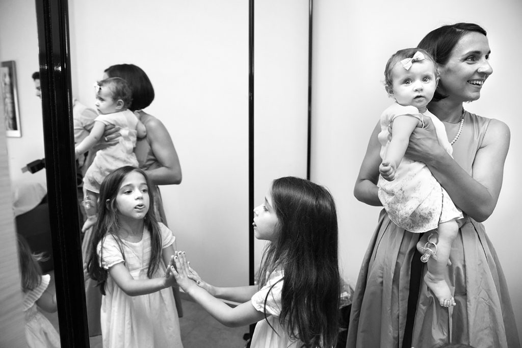 η μικρή βγάζει τη γλώσσα στον αντικατοπτρισμό της, η νονά κρατάει τη μικρή αγκαλιά