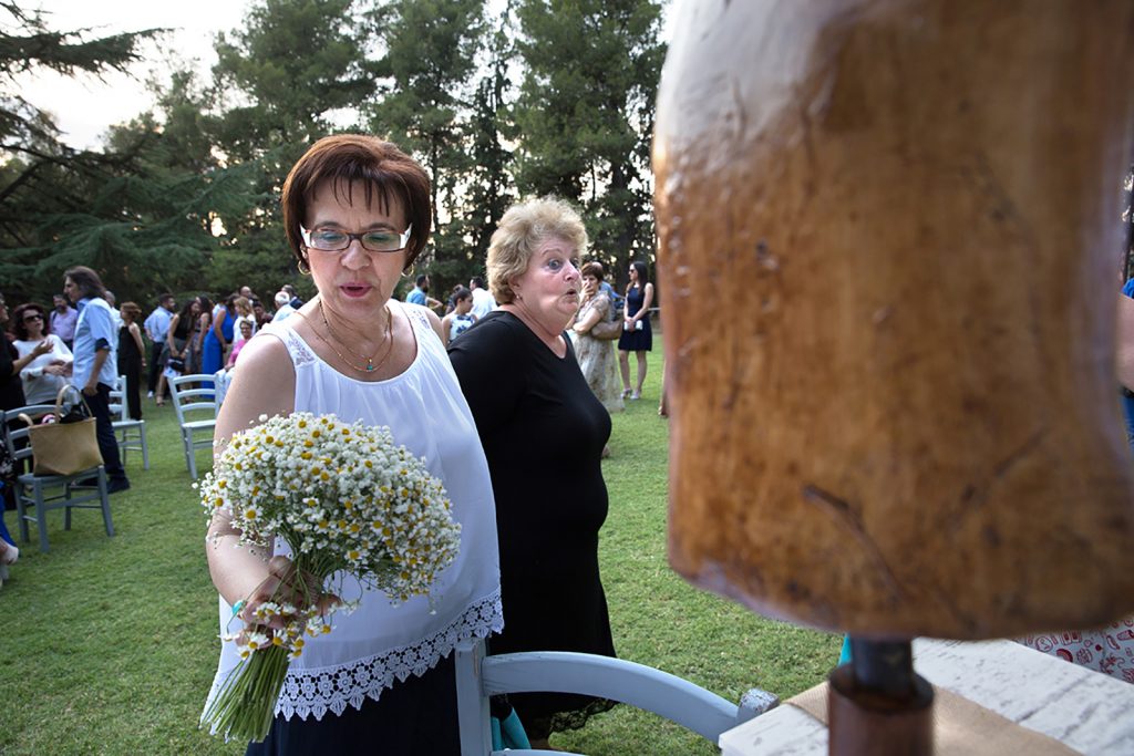 μια καλεσμένη κρατάει την ανθοδέσμη, μια άλλη από πίσω της γουρλώνει τα μάτια, γάμος και βάπτιση μαζί, ο φωτογράφος γάμου παρουσιάζει μια γαμοβάπτιση στη Θεσσαλονίκη.