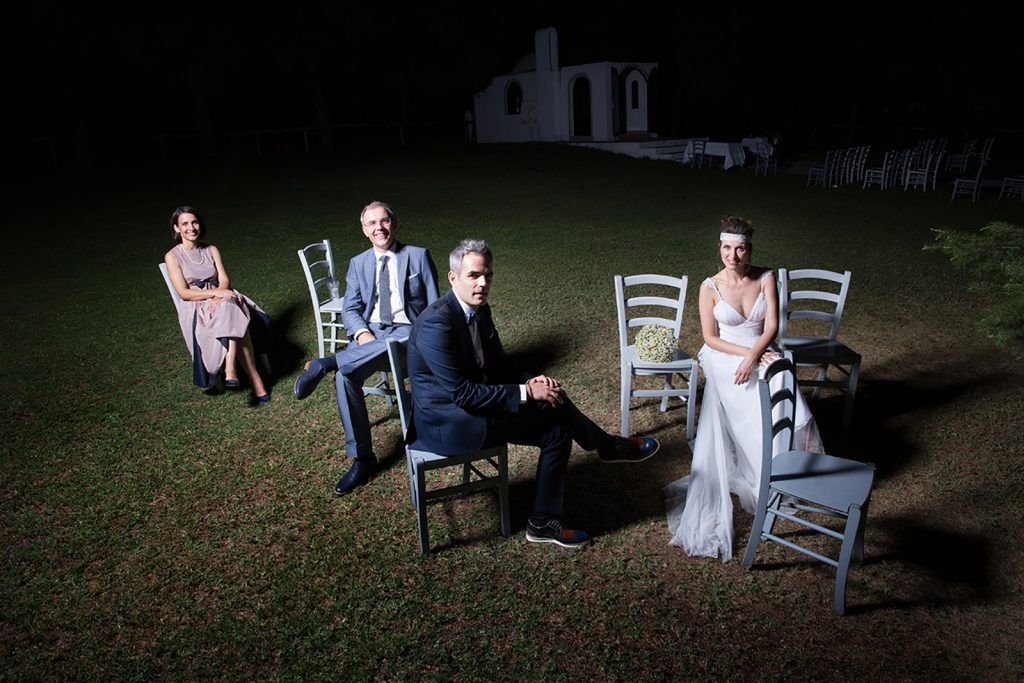 το ζευγάρι και οι κουμπάροι κάθονται σε ξύλινες καρέκλες, γάμος και βάπτιση μαζί, ο φωτογράφος γάμου παρουσιάζει μια γάμο βάπτιση στη Θεσσαλονίκη