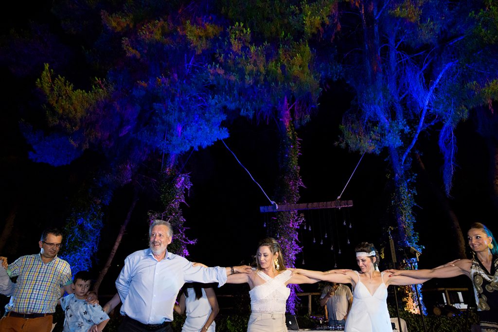 χορεύουν οι καλεσμένοι, πίσω τους φώτο χρώματος μωβ