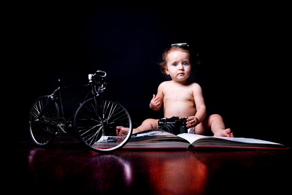 φωτογραφία στο στούντιο. Ποδηλατάκι δίπλα στη μικρή