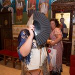 κυρία κρύβει το πρόσωπό της με μια βεντάλια.