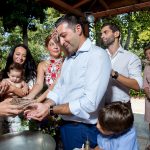 ο ιερές τοποθετεί λάδι στις χούφτες του νονού.