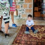 μικρός κάθεται σε ένα χαλί.