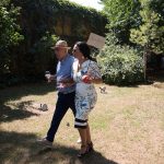 η μητέρα με έναν καλεσμένο αγκαζέ, κρατάει μια πινακίδα.